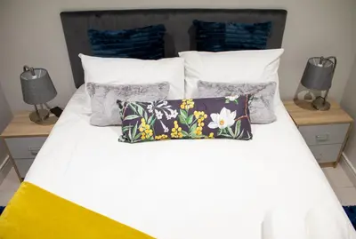 a bedroom with a white bed with pillows at Modern 1 Bedroom Executive Apartment in Waterfall in Midrand