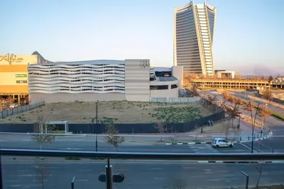 a view of a city with a building and a street at Modern 1 Bedroom Executive Apartment in Waterfall in Midrand