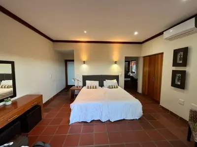 a bedroom with a white bed and a television at Elements Private Golf Reserve Unit 149 or 150 in Bela-Bela