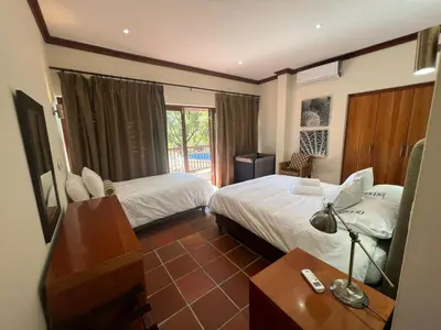 a hotel room with two beds and a table with a lamp at Elements Private Golf Reserve Unit 149 or 150 in Bela-Bela