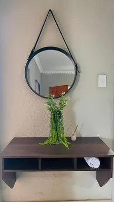 a mirror on top of a wooden table with a plant at Zinathi Lodge in Lebowakgomo