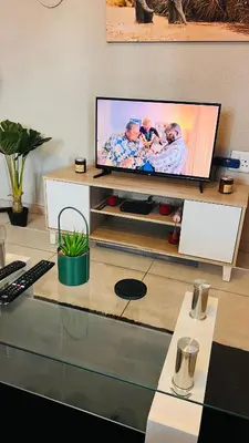 a flat screen tv sitting on a entertainment center at Zinathi Lodge in Lebowakgomo