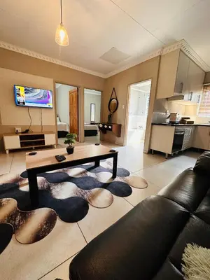 a living room with a couch and a table at Zinathi Lodge in Lebowakgomo