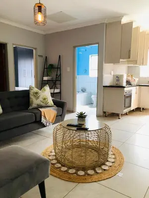 a living room with a couch and a table at Zinathi Lodge in Lebowakgomo