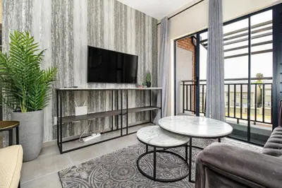 a living room with a television and a table at Smartz Apartment 334 in Midrand