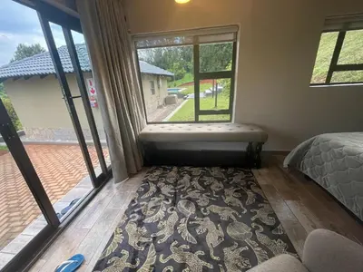 a bedroom with a bed and a large window at Langalanga on the mountain bend in Tzaneen