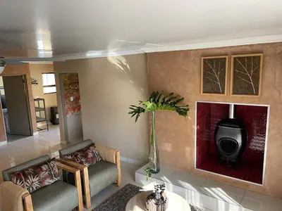 a living room with two chairs and a tv at Langalanga on the mountain bend in Tzaneen