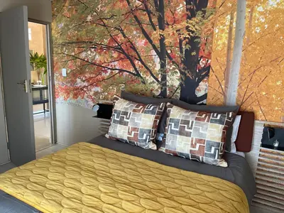 a bedroom with a bed with a painting on the wall at Langalanga on the mountain bend in Tzaneen