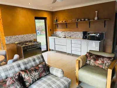 a kitchen with two couches and a stove at Langalanga on the mountain bend in Tzaneen