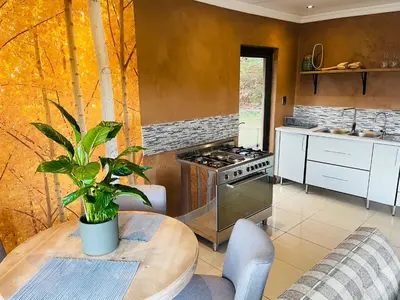 a kitchen with a wooden table with a potted plant at Langalanga on the mountain bend in Tzaneen