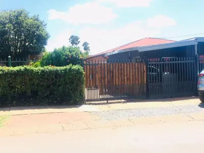 a gate in front of a house with bushes at Mighty7 Guesthouse in Pretoria