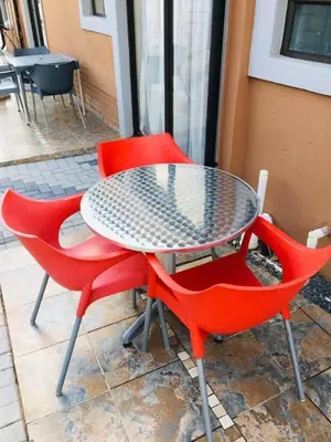 a table and two red chairs sitting next to each other at Mighty7 Guesthouse in Pretoria