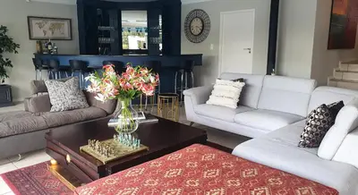 a living room with couches and a vase of flowers on a coffee table at Luxury Boutique Home in Kyalami in Midrand