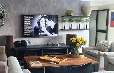 a living room with a tv on the wall at Luxury Boutique Home in Kyalami in Midrand