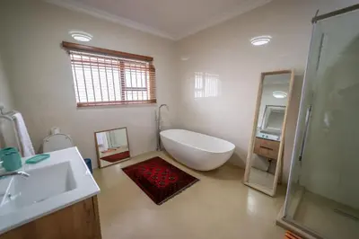 a bathroom with a tub and a sink and a mirror at Luxury Boutique Home in Kyalami in Midrand
