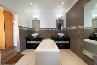 a bathroom with two sinks and a bath tub at Luxury Boutique Home in Kyalami in Midrand