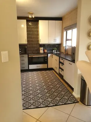 a kitchen with white cabinets and a tile floor at Luxury Boutique Home in Kyalami in Midrand