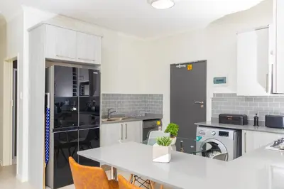 a kitchen with a table and chairs in it at Fumo House Lifestyle Apartments in Midrand