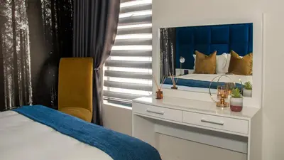 a bedroom with a bed and a dresser with a mirror at Fumo House Lifestyle Apartments in Midrand