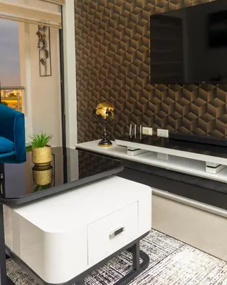 a living room with a tv and a white coffee table at Fumo House Lifestyle Apartments in Midrand