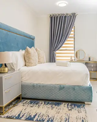 a bedroom with a large bed with a blue headboard at Fumo House Lifestyle Apartments in Midrand