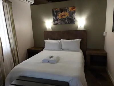 a bedroom with a bed with two towels on it at Aan De Vliet Holiday Resort in Hazyview