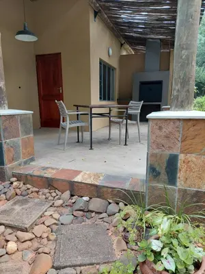 a patio with a table and chairs in a house at Aan De Vliet Holiday Resort in Hazyview