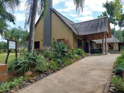 a building with a gambrel roof and a driveway at Aan De Vliet Holiday Resort in Hazyview