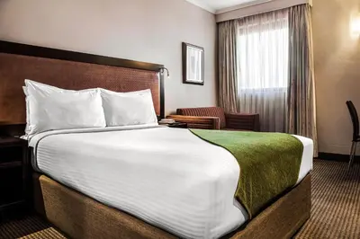 a hotel room with a large bed and a window at The RidgePoint Hotel in Witbank