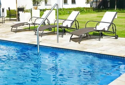 a group of chairs next to a swimming pool at The RidgePoint Hotel in Witbank