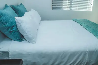 a bed with blue and white pillows on it at Platinum Apartment in Polokwane