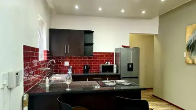 a kitchen with a counter and a refrigerator at Platinum Apartment in Polokwane