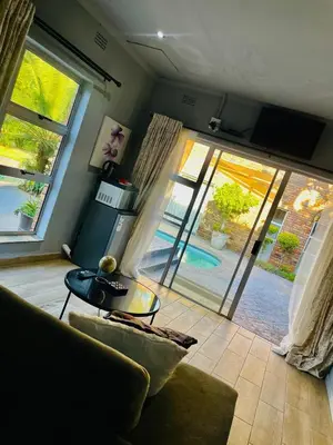 a living room with a couch and a large window at The Bliss Boutique in Louis Trichardt