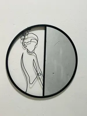 a mirror with a drawing of a woman on a wall at The Bliss Boutique in Louis Trichardt