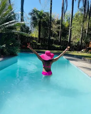a woman in a pink hat in a swimming pool at The Bliss Boutique in Louis Trichardt
