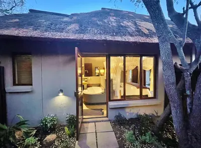 a house with a door open to a bedroom at 10 Raptors Lodge in Hoedspruit