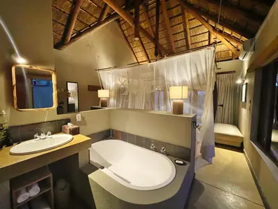 a bathroom with a bath tub and a sink at 10 Raptors Lodge in Hoedspruit
