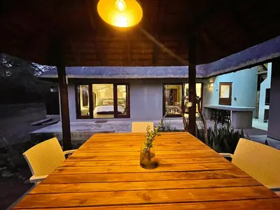a wooden table with a vase on top of it at 10 Raptors Lodge in Hoedspruit