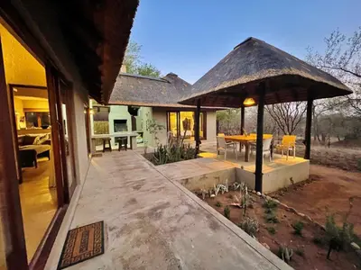 a house with a patio with a table and a pavilion at 10 Raptors Lodge in Hoedspruit