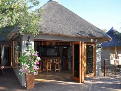 a building with a thatched roof with a patio at Mount Marula Game Lodge - Tambotie in Kwarriekraal