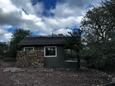 a small house with a stone wall at Mount Marula Game Lodge - Tambotie in Kwarriekraal