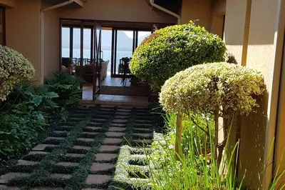 a garden with plants and a walkway in front of a house at Pecanwood Home Away from Home in Hartbeespoort