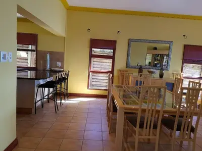 a kitchen and dining room with a table and chairs at Pecanwood Home Away from Home in Hartbeespoort
