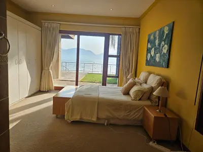 a bedroom with a large bed and a large window at Pecanwood Home Away from Home in Hartbeespoort