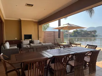 a restaurant with a large table with chairs and an umbrella at Pecanwood Home Away from Home in Hartbeespoort