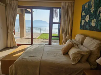 a bedroom with a bed with a view of the ocean at Pecanwood Home Away from Home in Hartbeespoort