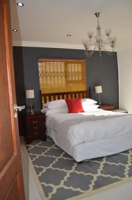 a bedroom with a large bed with a red pillow at Honolulu Lifestyle Guest Lodge in Burgersfort