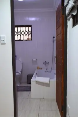 a white bathroom with a tub and a toilet at Honolulu Lifestyle Guest Lodge in Burgersfort