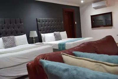 a hotel room with two beds and a couch at Honolulu Lifestyle Guest Lodge in Burgersfort
