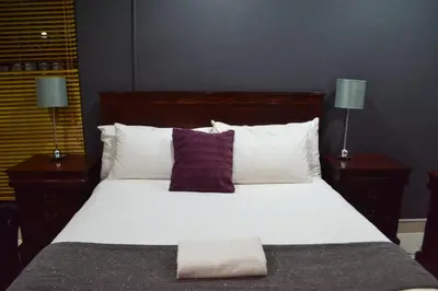 a bedroom with a large bed with white sheets and pillows at Honolulu Lifestyle Guest Lodge in Burgersfort